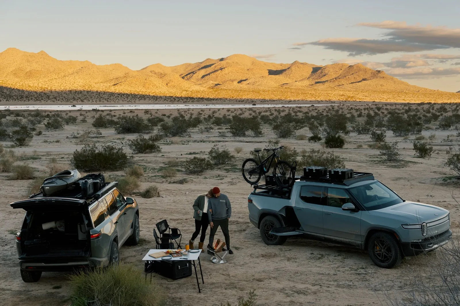 Desert camp at dusk, bikes racked, the range behind